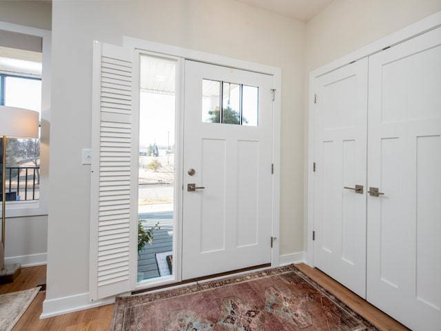 foyer entrance featuring light wood-style flooring and baseboards