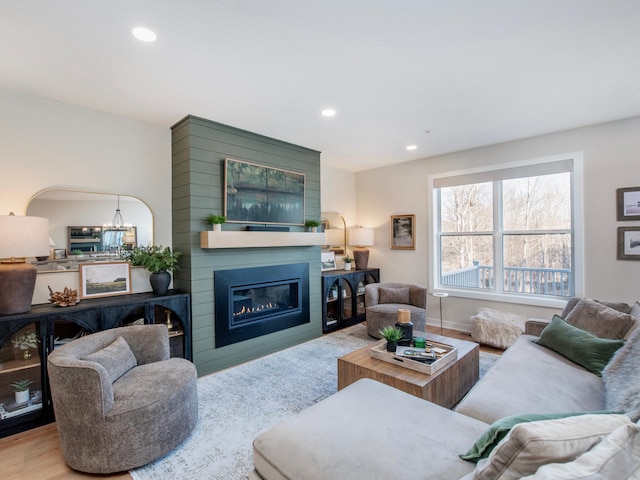 living room with a large fireplace, baseboards, wood finished floors, and recessed lighting