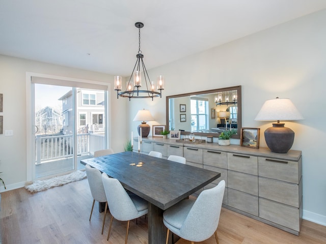 dining area with a healthy amount of sunlight, light wood-style floors, baseboards, and a chandelier