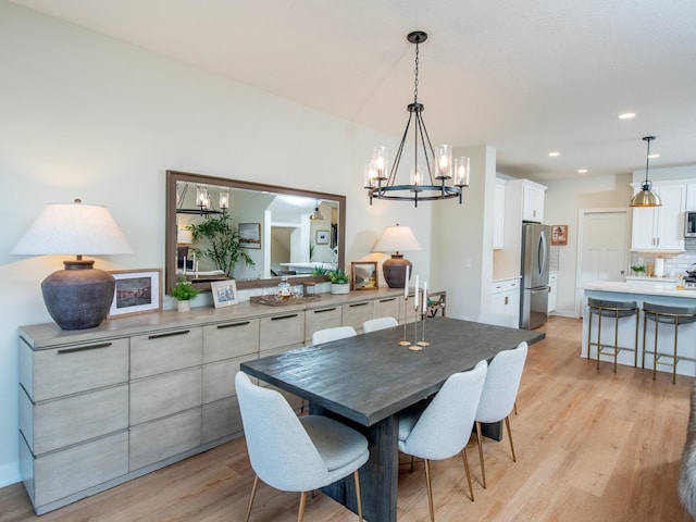 dining room with light wood-style floors, a chandelier, and recessed lighting