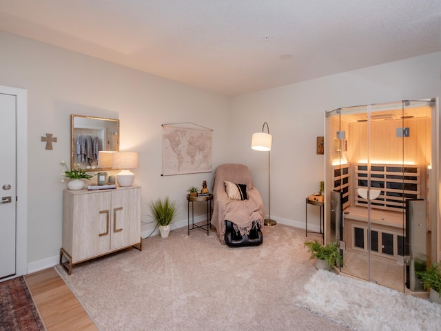 sitting room with carpet floors, a sauna, and baseboards