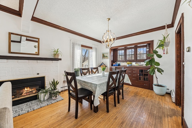 dining area featuring crown molding, a textured ceiling, a baseboard heating unit, and hardwood / wood-style floors