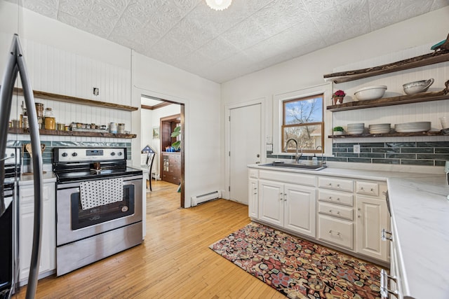 kitchen with a sink, open shelves, light wood-style floors, electric range, and a baseboard radiator