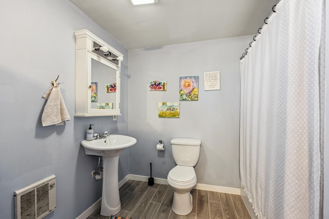 bathroom featuring visible vents, baseboards, wood finish floors, toilet, and a sink