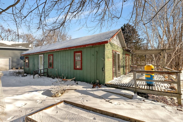 view of snow covered exterior featuring a deck and board and batten siding