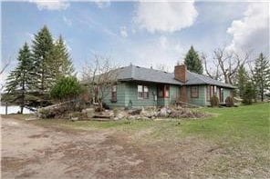 view of front of house featuring a chimney and a front yard