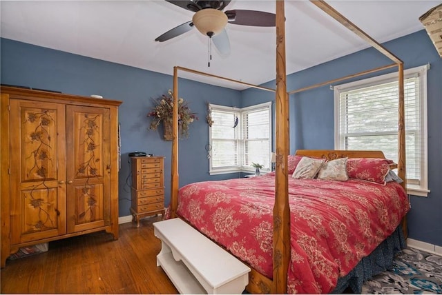 bedroom featuring a ceiling fan, baseboards, and wood finished floors