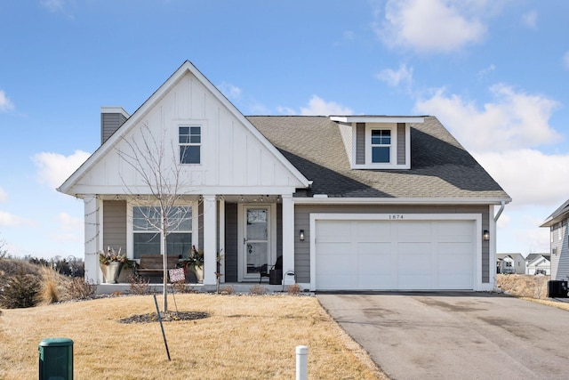 view of front of home featuring driveway, a shingled roof, an attached garage, a porch, and board and batten siding