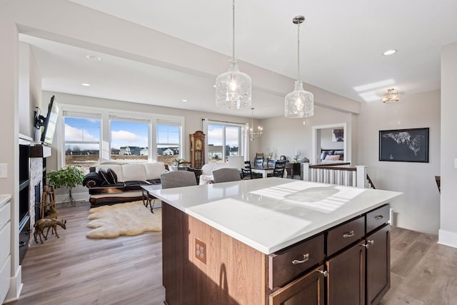 kitchen with light wood-type flooring, open floor plan, light countertops, and recessed lighting