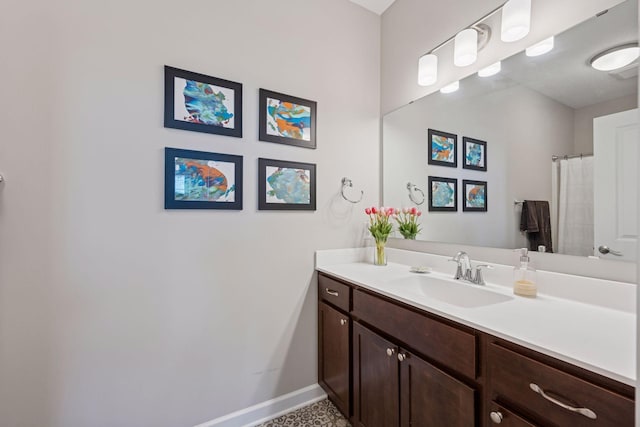 full bath featuring vanity and baseboards