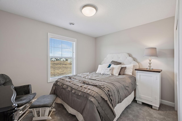 carpeted bedroom with baseboards and a textured ceiling