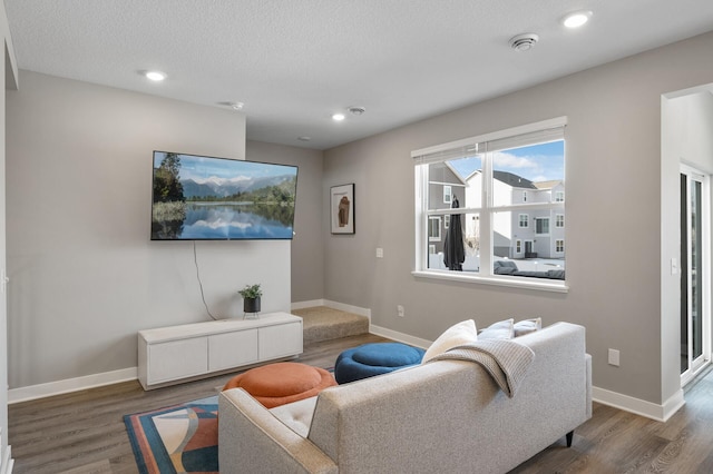 living room with recessed lighting, baseboards, and wood finished floors