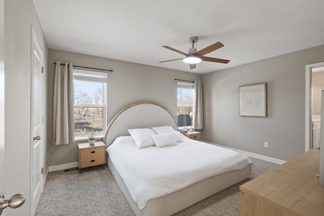 bedroom with a ceiling fan, light colored carpet, baseboards, and multiple windows