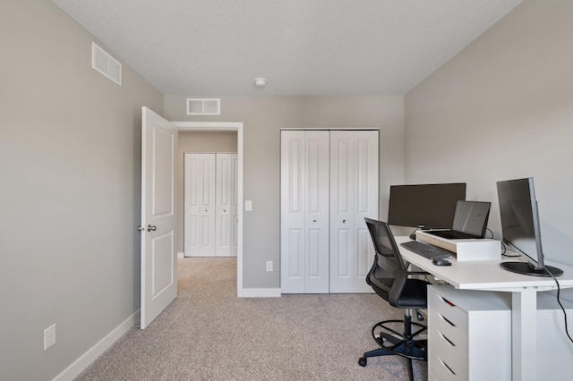 unfurnished office featuring carpet floors, visible vents, and baseboards