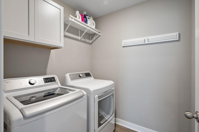 laundry room with separate washer and dryer, cabinet space, and baseboards