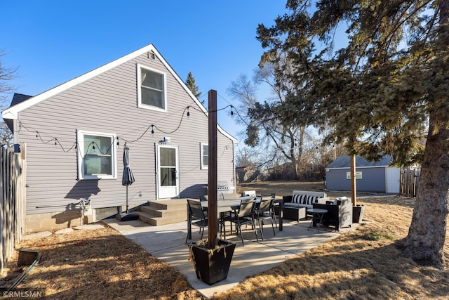 back of property with an outbuilding, a patio area, and an outdoor living space