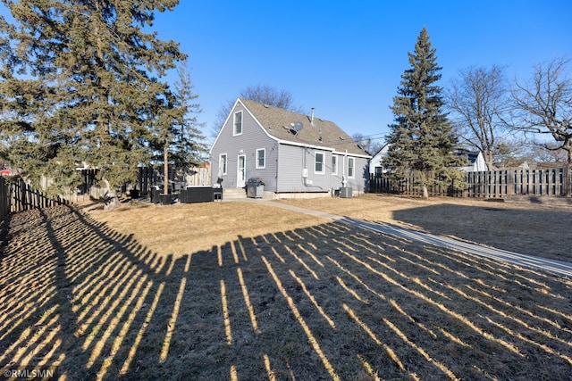 rear view of house featuring a shingled roof and fence