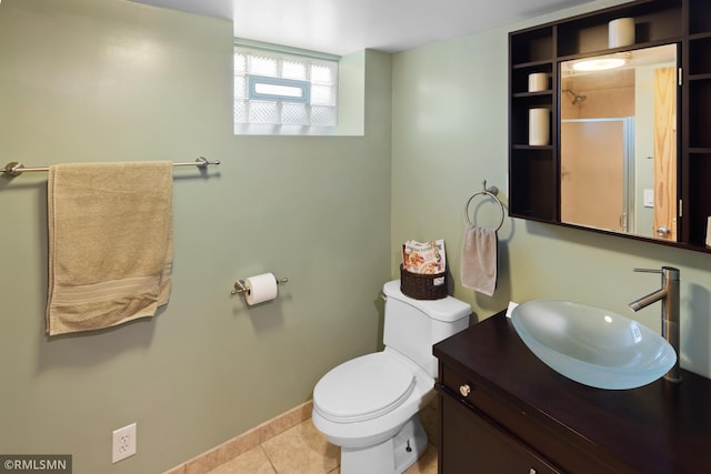 full bath featuring a shower with door, toilet, vanity, baseboards, and tile patterned floors