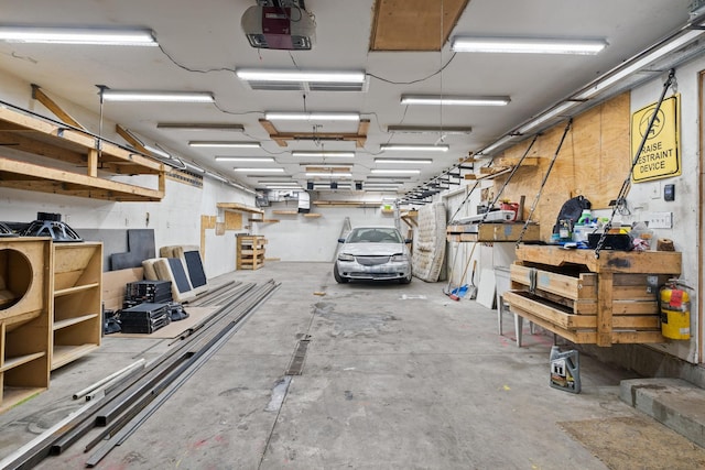 garage with a garage door opener and a workshop area