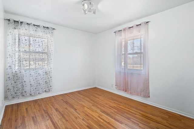 empty room featuring baseboards and wood finished floors