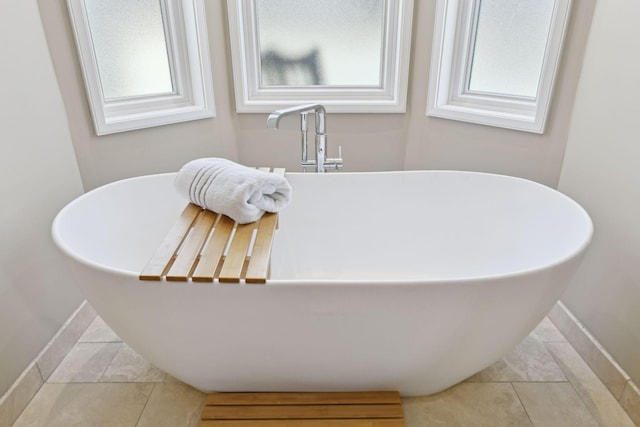 details with a soaking tub and baseboards