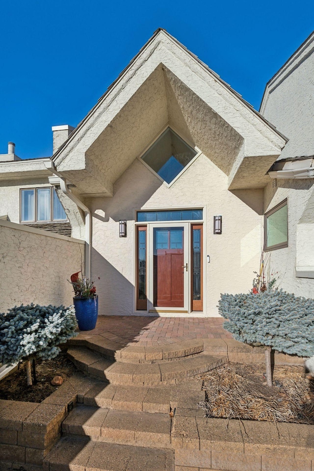 doorway to property featuring stucco siding