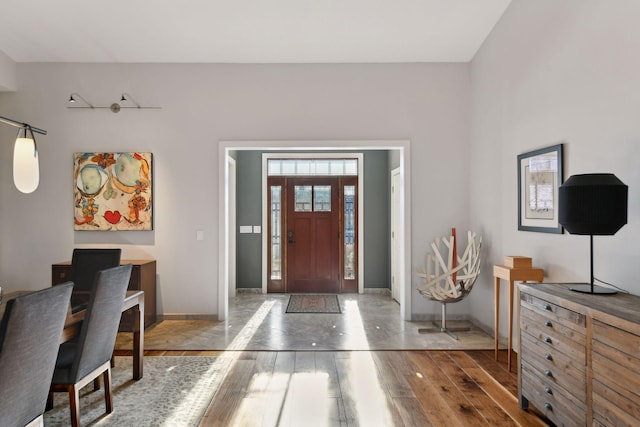 foyer entrance with wood-type flooring and baseboards