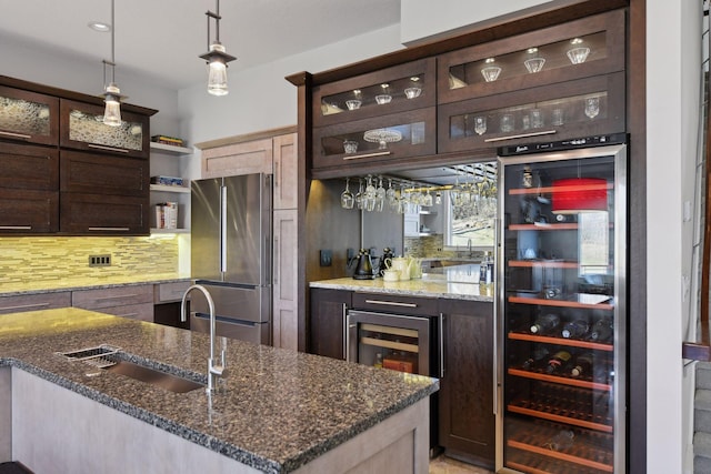 kitchen with a sink, dark brown cabinets, freestanding refrigerator, open shelves, and tasteful backsplash