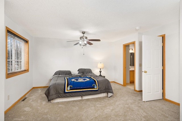 bedroom featuring light carpet, a textured ceiling, and baseboards