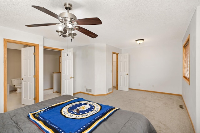 bedroom with light carpet, a textured ceiling, visible vents, and baseboards