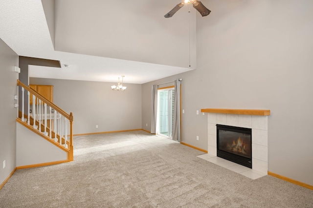 unfurnished living room with light carpet, stairway, a fireplace, and baseboards