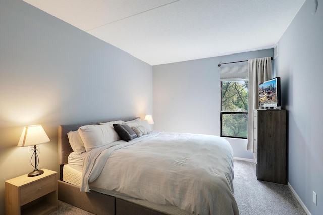 bedroom with light carpet and baseboards