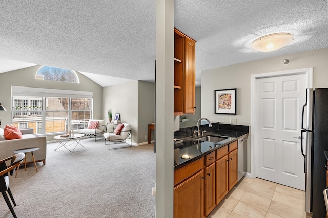 kitchen with lofted ceiling, open floor plan, appliances with stainless steel finishes, and a sink