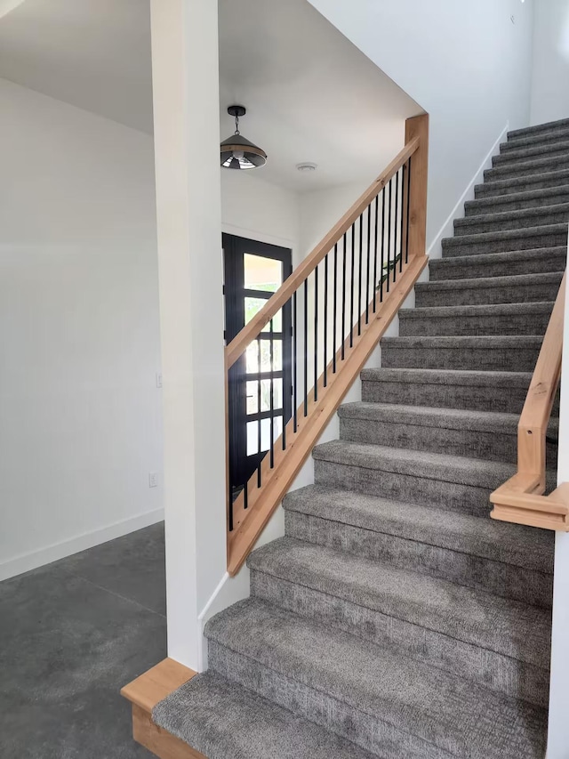 stairs featuring concrete floors and baseboards