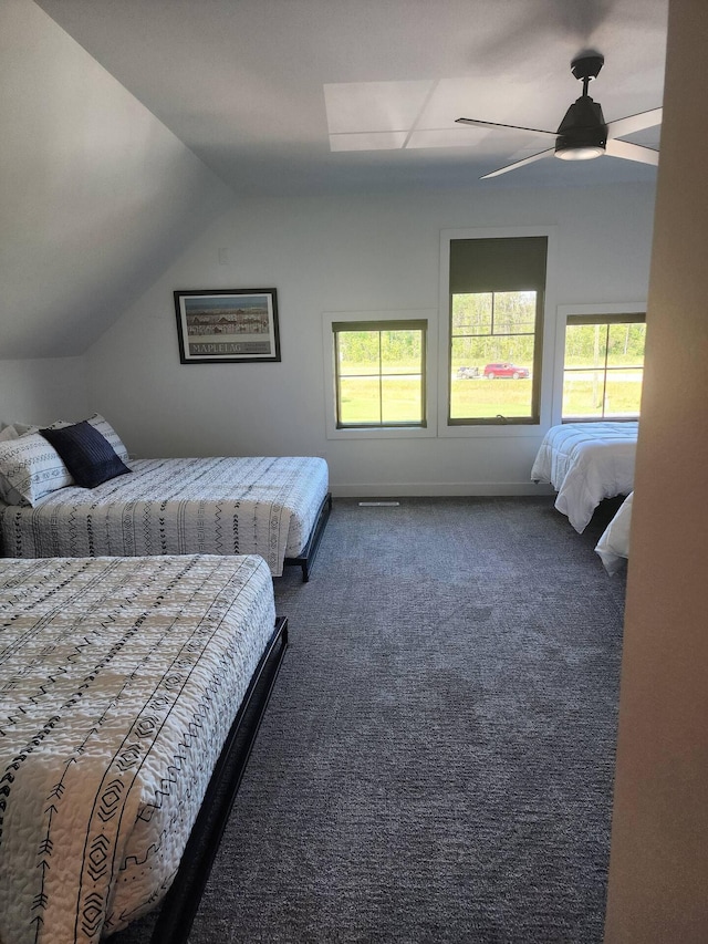 bedroom featuring lofted ceiling, baseboards, dark carpet, and a ceiling fan