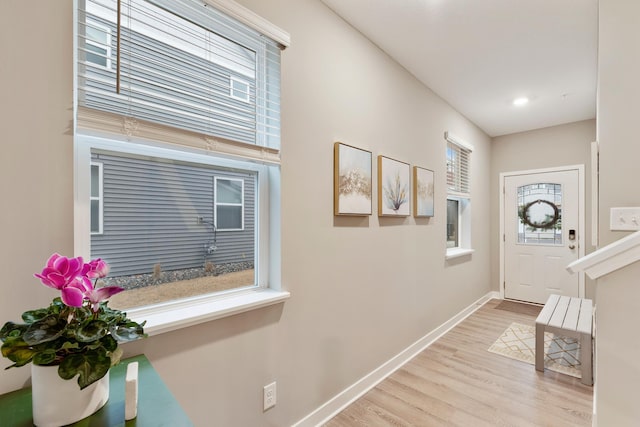 foyer featuring baseboards and wood finished floors