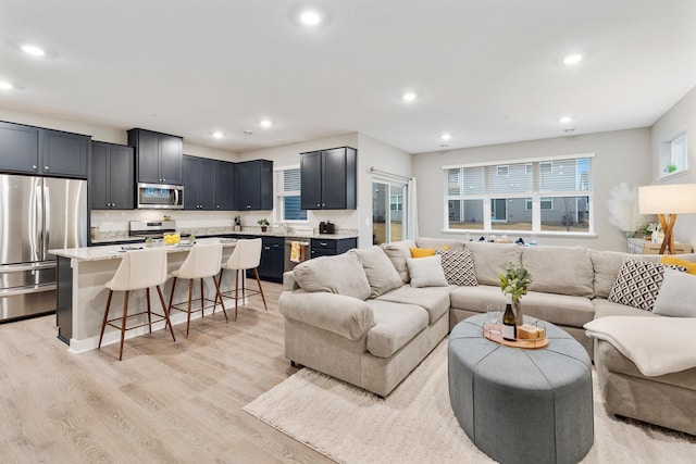 living area with light wood-type flooring and recessed lighting