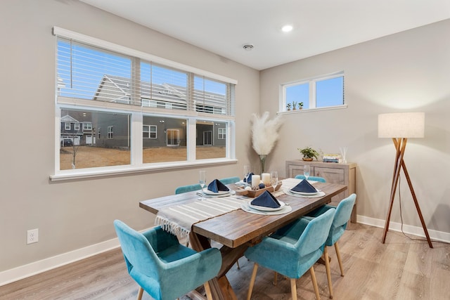 dining room featuring baseboards, wood finished floors, and recessed lighting