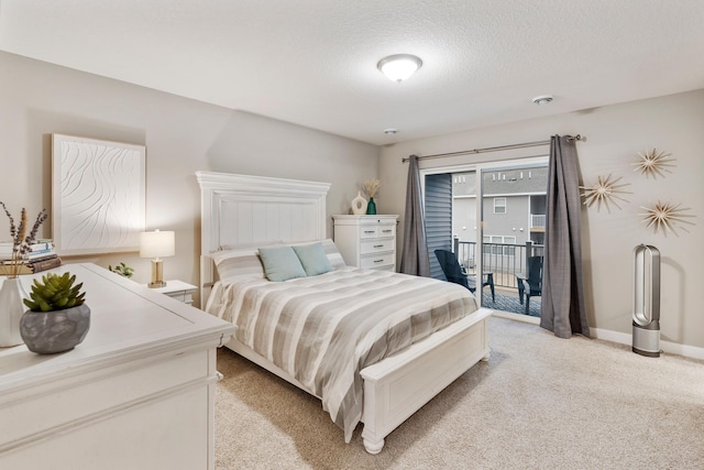 bedroom with access to exterior, light colored carpet, a textured ceiling, and baseboards