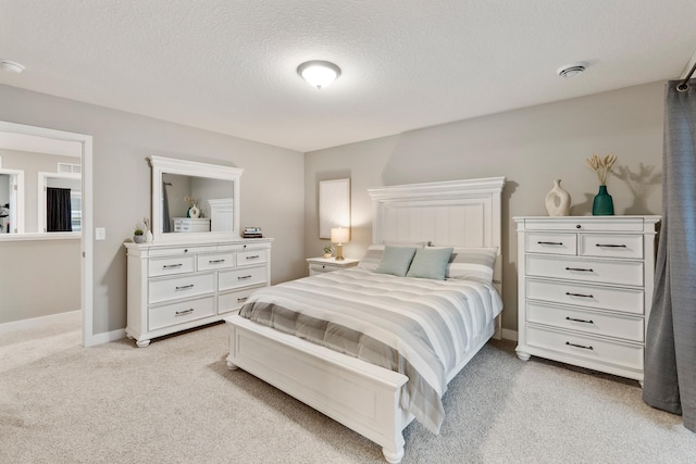 bedroom with light carpet, a textured ceiling, visible vents, and baseboards