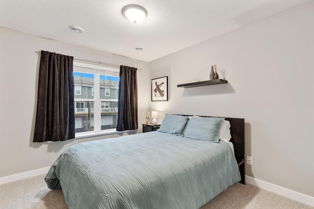 carpeted bedroom with a textured ceiling, visible vents, and baseboards