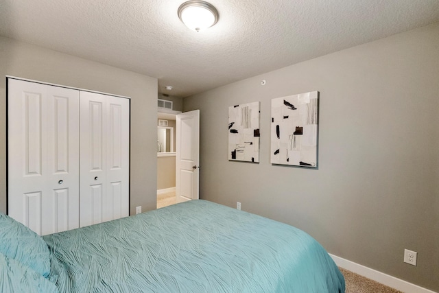 bedroom featuring visible vents, baseboards, a textured ceiling, carpet floors, and a closet