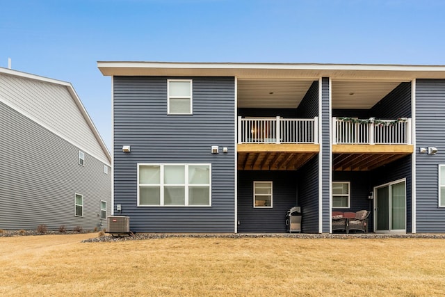 back of property with a yard and central AC unit