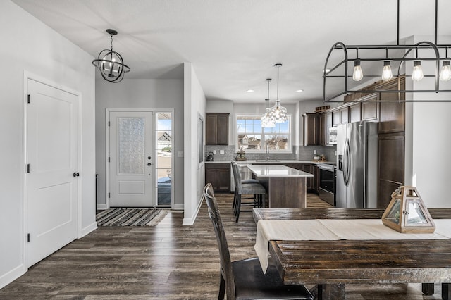 interior space with a chandelier, dark wood-type flooring, recessed lighting, and baseboards