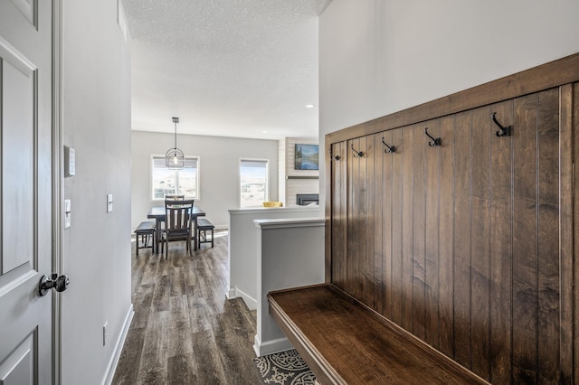 mudroom with baseboards, dark wood-style flooring, and a textured ceiling