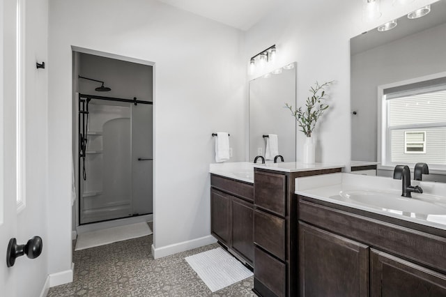 full bath with vanity, baseboards, and a walk in shower