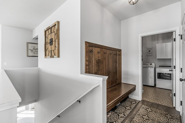 mudroom featuring washer and dryer, baseboards, and wood finished floors