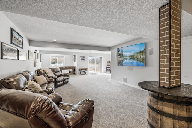 living room with a textured ceiling, visible vents, baseboards, carpet, and decorative columns