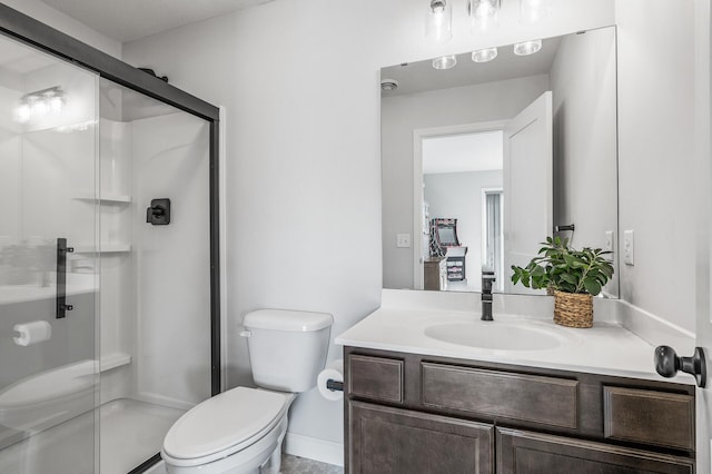 bathroom with vanity, a shower stall, and toilet