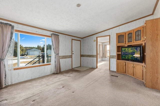 unfurnished living room featuring light carpet, ornamental molding, a textured ceiling, and wallpapered walls